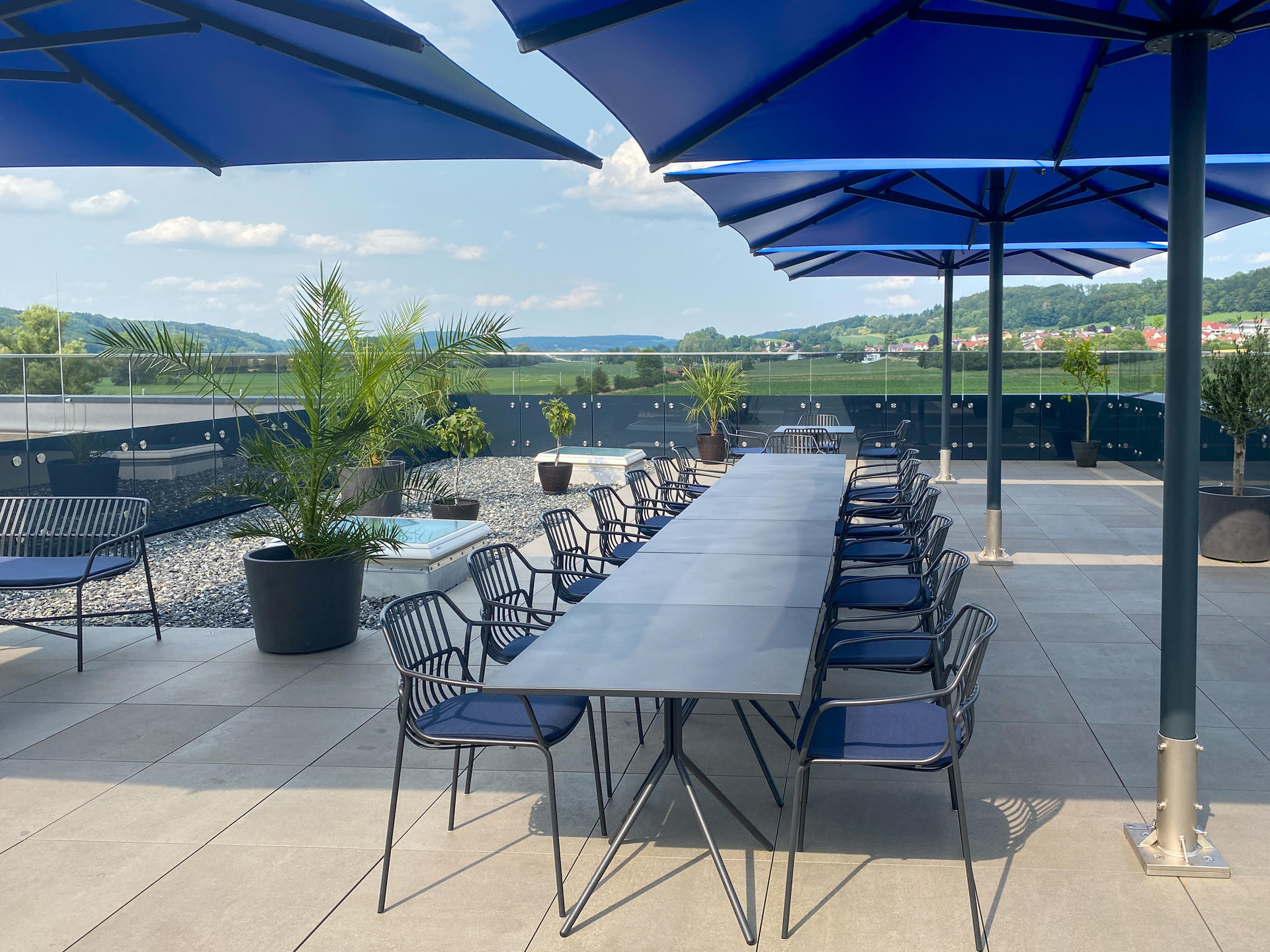 Dachterrasse mit blauen Sonnenschirmen